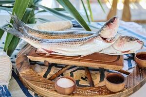 dos pescado descansando en de madera bandeja foto