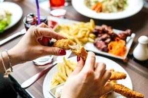 persona comiendo comida a mesa con utensilios foto