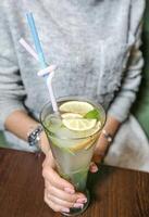 Woman Holding Glass of Lemonade With Straw photo