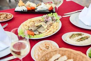 mesa adornado con platos de comida y lentes de vino foto