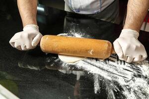 Person Rolling Dough on Kitchen Counter photo