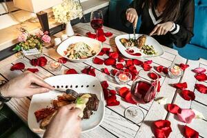 Pareja disfrutando un comida juntos a un mesa con platos de comida foto