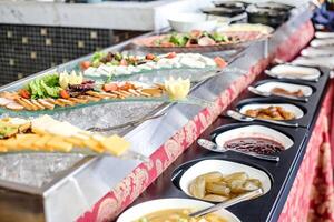 un multitud de comida opciones a un buffet línea foto