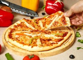 Person Cutting Pizza on a Wooden Cutting Board photo