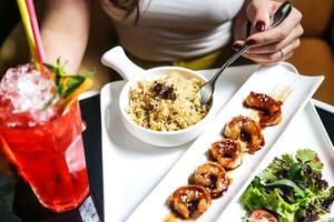 mujer sentado a mesa con plato de comida y bebida foto