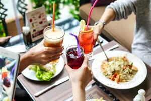 grupo de personas disfrutando bebidas a un mesa foto