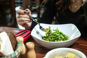 Woman Eating Bowl of Food With Fork photo