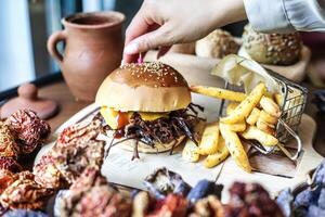 persona colocación palillo de dientes en hamburguesa empanada foto