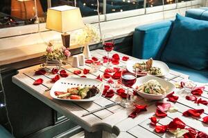 Table With Assorted Food Plates and Glasses of Wine photo