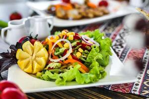 Fresh Salad on White Plate, Surrounded by Other Food photo