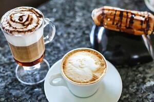 taza de capuchino y caliente perro en mesa foto