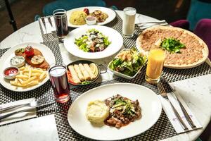 Table Set With Assorted Plates of Food and Drinks photo