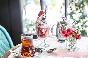 Table With Two Cups of Tea and Pitcher of Ice Cream photo