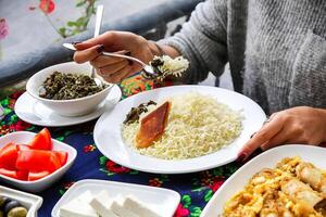 persona disfrutando un comida desde un plato en un mesa foto