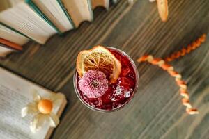 Glass of Lemonade Next to an Open Book on a Wooden Table photo