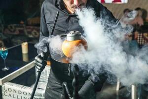 Man in Black Shirt Holding Smoking Kettle photo