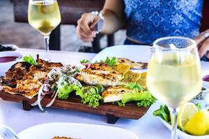 Table Adorned With Plates of Food and Glasses of Wine photo