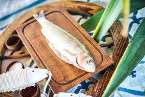 pescado sentado en de madera corte tablero foto