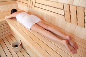 joven mujer relajante en sauna, parte superior vista. spa tratamiento concepto foto