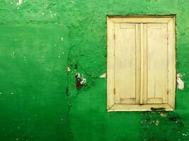 Clásico de madera ventana en un grieta verde pared con Copiar espacio para anuncios foto