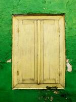 vintage wooden window on a crack green wall photo