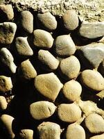 wall of round Pebble Stones as a background Pattern of boulders with copy space for ads photo