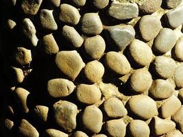 wall of round Pebble Stones as a background Pattern of boulders with copy space for ads photo