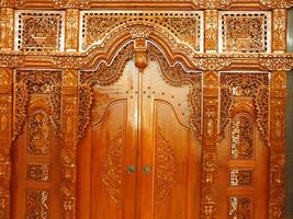 The beauty art of a traditional javanese teak carved door. People called it a gebyok door. photo