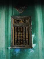 vintage wooden window on a crack green wall photo