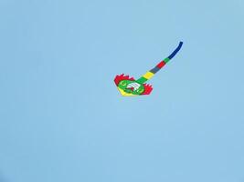 Beautiful kite flies in a clear and blue sky on a sunny day. enjoy the wind. photo