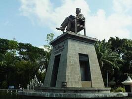 Surakarta, Central Java, Indonesia April 11, 2024. The statue of Mr Soekarno sitting while reading a book, statue of the first president of The Republik Indonesia at Manahan Stadium. photo