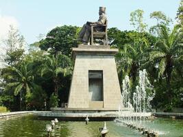 Surakarta, Central Java, Indonesia April 11, 2024. The statue of Mr Soekarno sitting while reading a book, statue of the first president of The Republik Indonesia at Manahan Stadium. photo