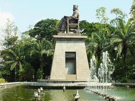 Surakarta, central Java, Indonesia abril 11, 2024. el estatua de señor soekarno sentado mientras leyendo un libro, estatua de el primero presidente de el republik Indonesia a manahan estadio. foto