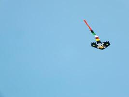 Beautiful kite flies in a clear and blue sky on a sunny day. enjoy the wind. photo