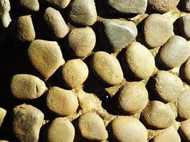 wall of round Pebble Stones as a background Pattern of boulders with copy space for ads photo