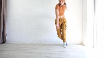 mujer en amarillo ropa bailando cadera salto o moderno danza en blanco estudio, ver desde detrás video