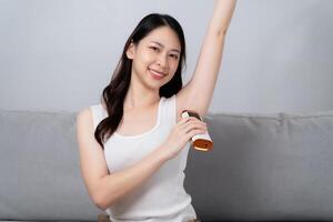 A beautiful woman is epilating her armpits using an IPL laser hair removal epilator device. photo