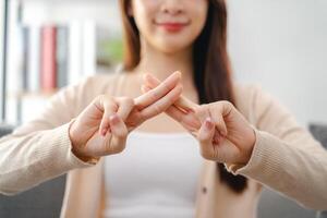 A young deaf woman is sitting on a couch and making a sign Language to communicate. photo