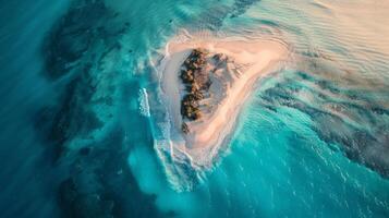 A breathtaking aerial view of a sandy island surrounded by crystal clear Caribbean water. The natural landscape includes a beautiful beach and fluid wind waves photo