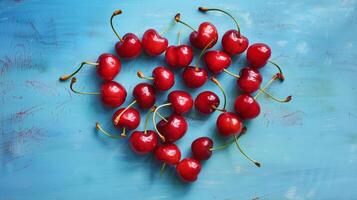 Heart shape made from ripe cherry fruits on a blue background. photo