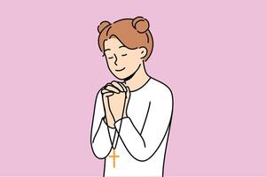 Little girl reads prayer, crossing palms near chest and holding christian cross in hands vector