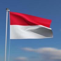 Indonesia Flag is waving in front of a blue sky with blurred clouds in the background photo