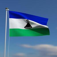 Lesotho Flag is waving in front of a blue sky with blurred clouds in the background photo