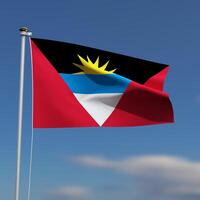 Antigua and Barbuda Flag is waving in front of a blue sky with blurred clouds in the background photo