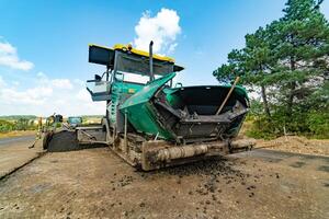 A close view of a heavy machinery working on a new road construction site. Road roller at a road construction site. photo