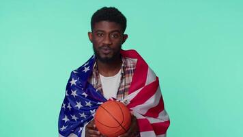 Bearded young man basketball fan holding American USA flag doing winner gesture, dancing alone video