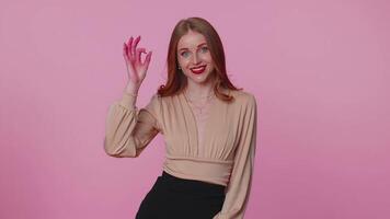 Positive businesswoman girl showing ok gesture, like sign positive something good on pink background video