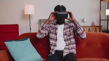 Young man use virtual reality headset glasses at home, enjoying concept moving hands in air video