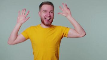 Funny joyful man making playful silly facial expressions, grimacing, fooling around showing tongue video