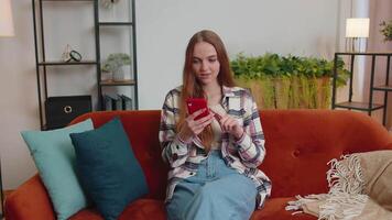 jong volwassen vrouw Bij huis gebruik mobiel cel telefoon typen browsen zeggen Wauw Ja gevonden uit Super goed groot winnen video